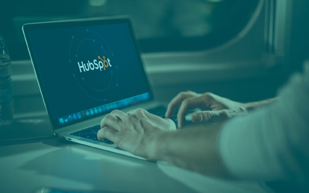 une personne qui est devant son ordinateur avec Hubspot sur l'écran